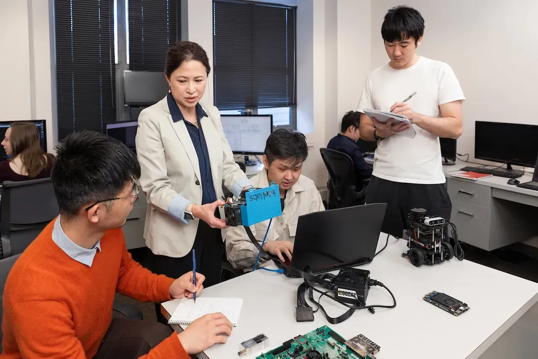 Professor working with students in a computer lab.